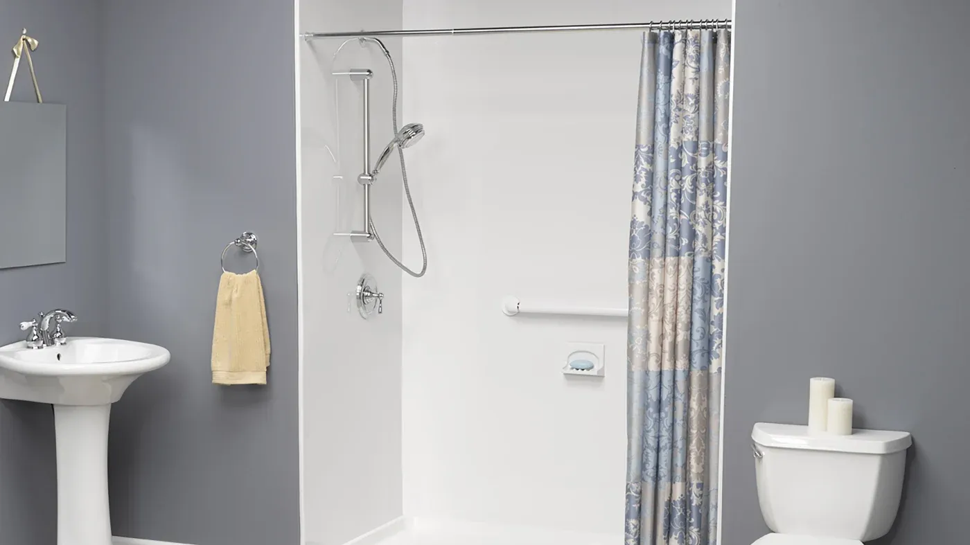 Bathroom with gray walls and new open shower with detachable shower head and white surround.