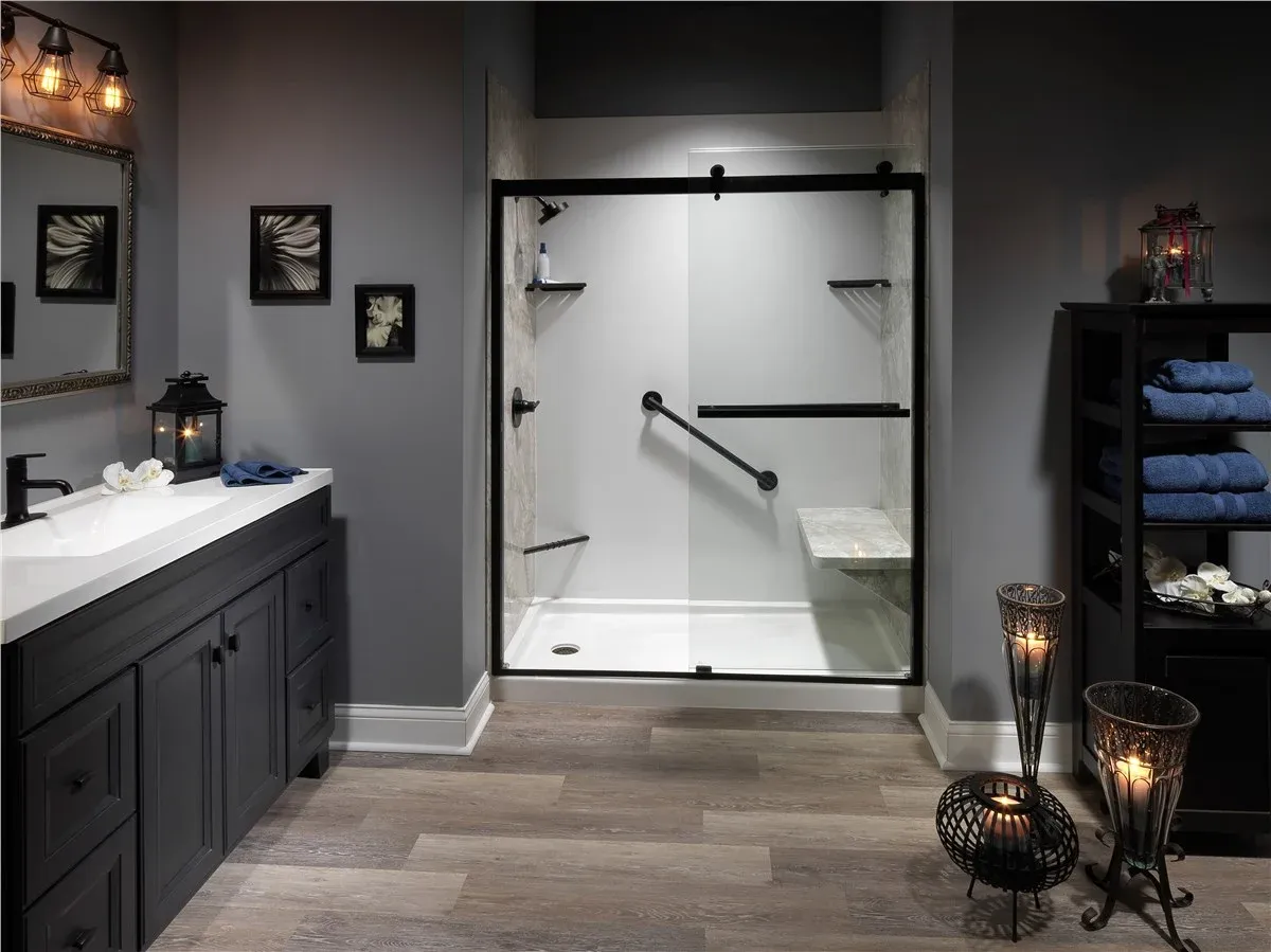 Gray bathroom featuring a white walk-in shower with black fixtures and a built-in bench seat.